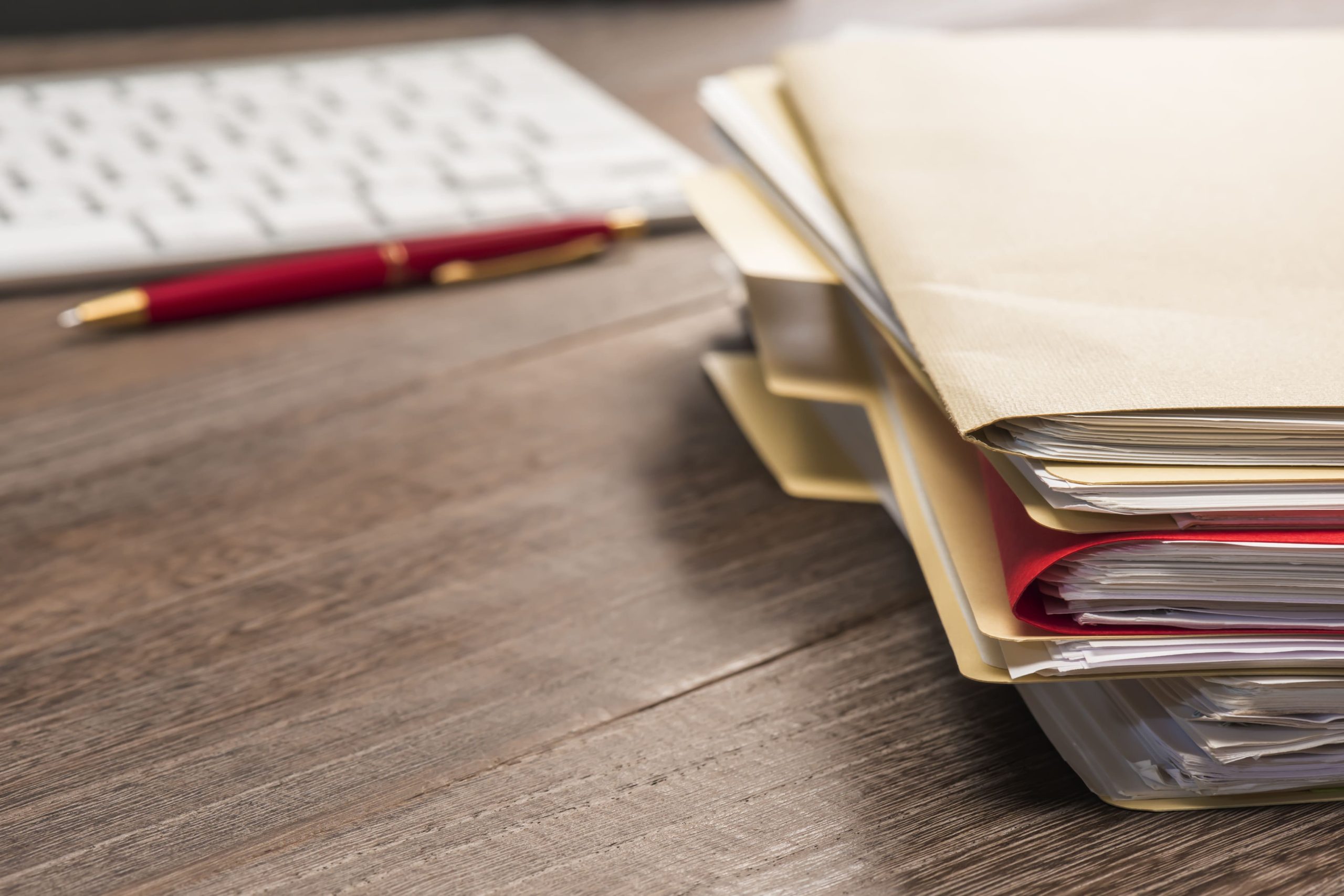 Image of some paperwork, a pen and a keyboard on a table